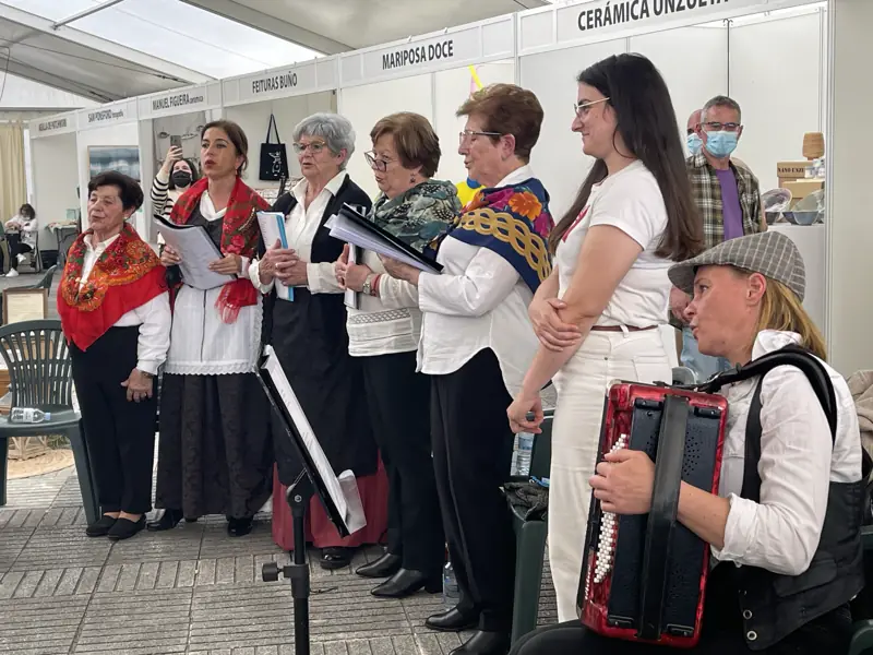 Cantoras con panos de cores e a acordeonista sentada á dereita